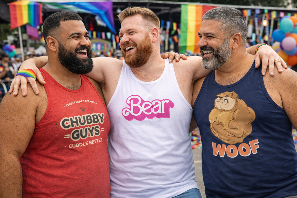 Three men wearing Pocket Bears Apparel tank tops with humorous text at a Pride parade.