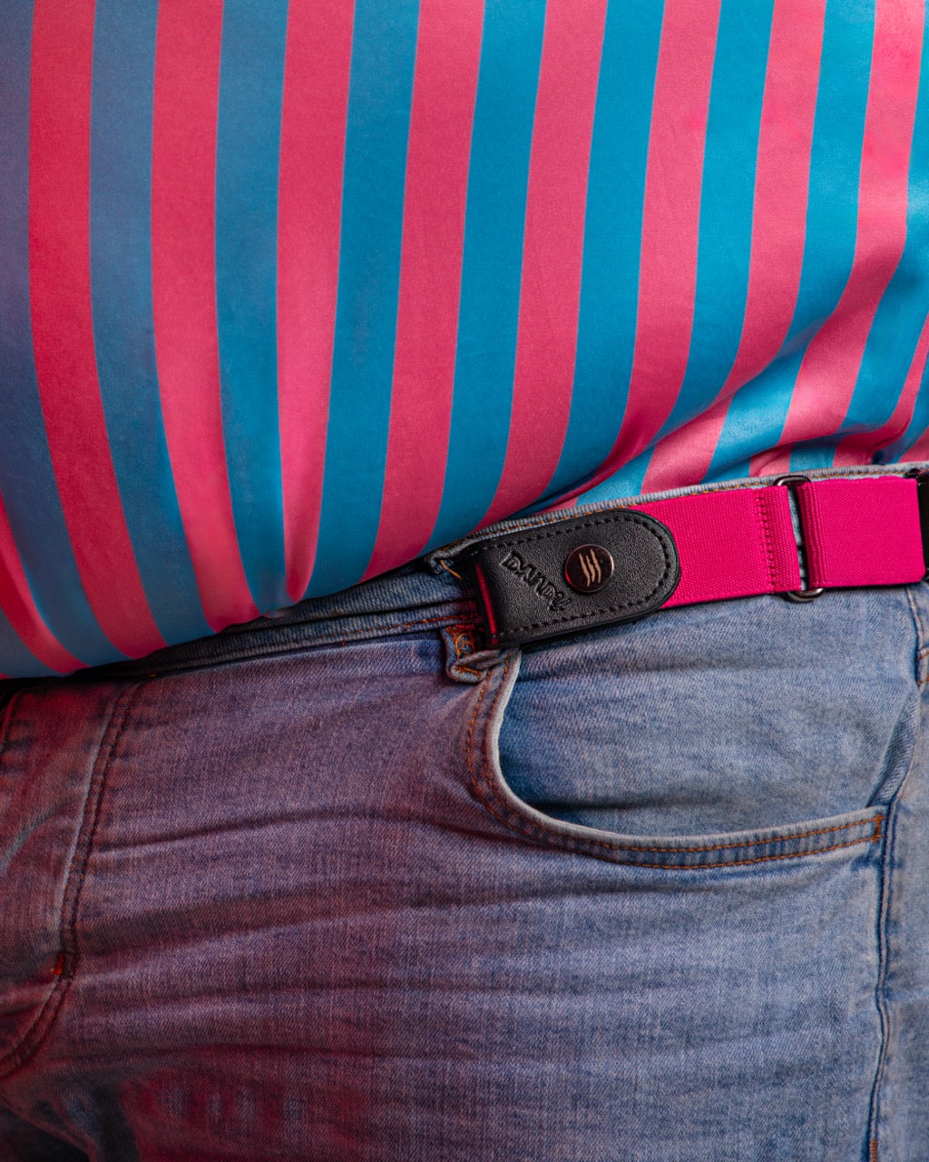 Close-up of a person wearing a striped shirt with pink and blue horizontal stripes, paired with jeans and a Bear Belts belt.